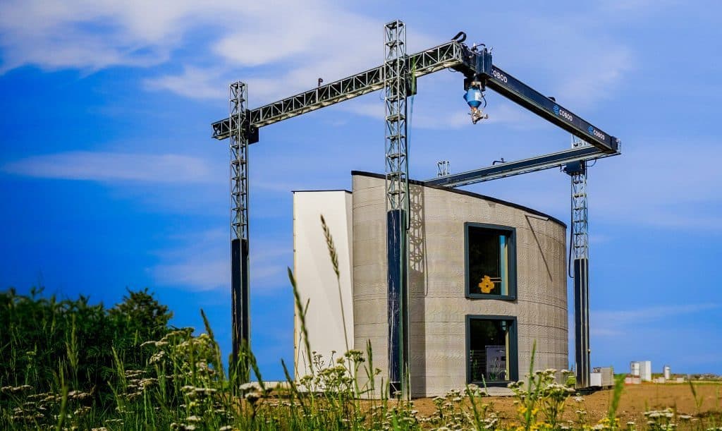 3D printed house with the BOD2 3D construction printer around it