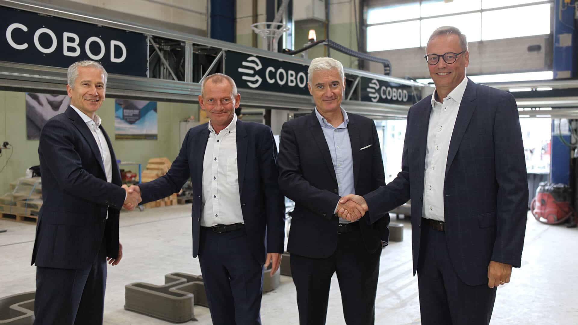 Executives from COBOD and Holcim shaking hands