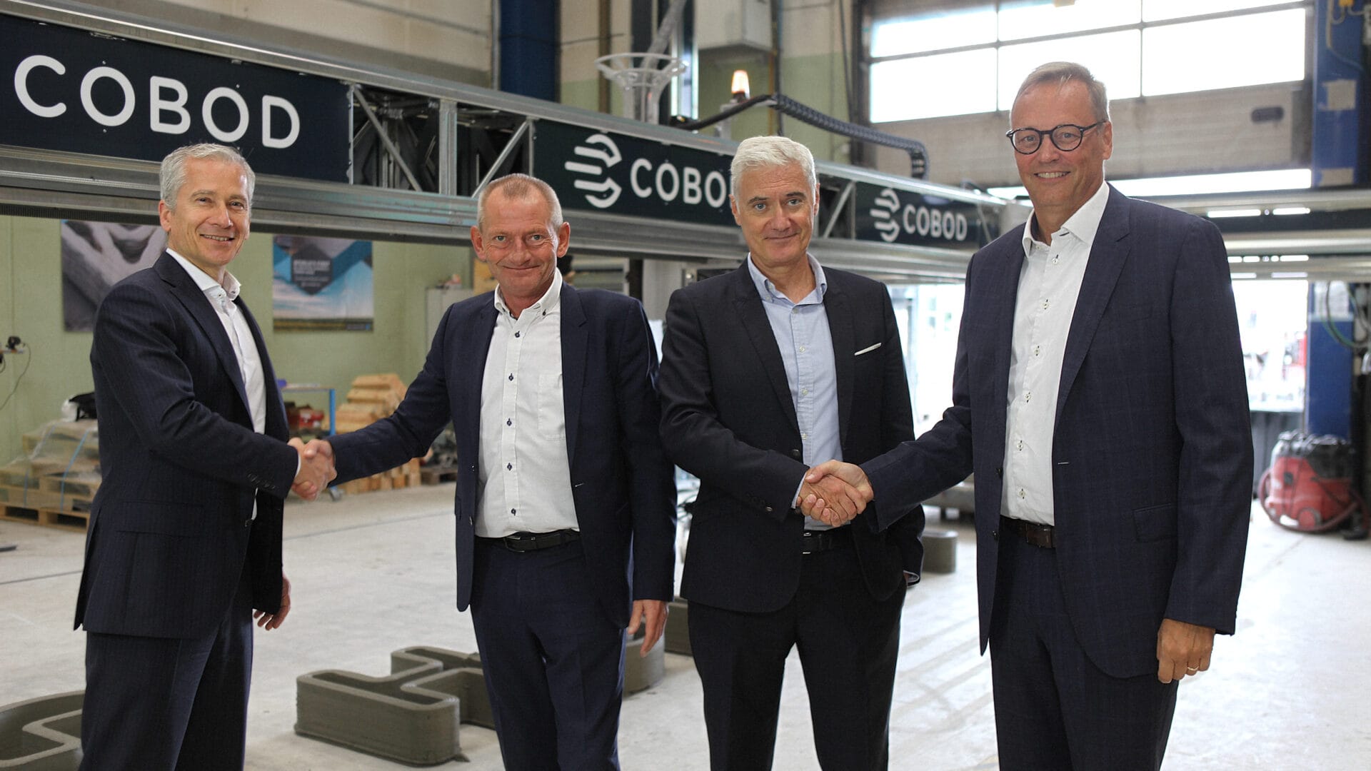 Executives from Holcim and COBOD shaking hands