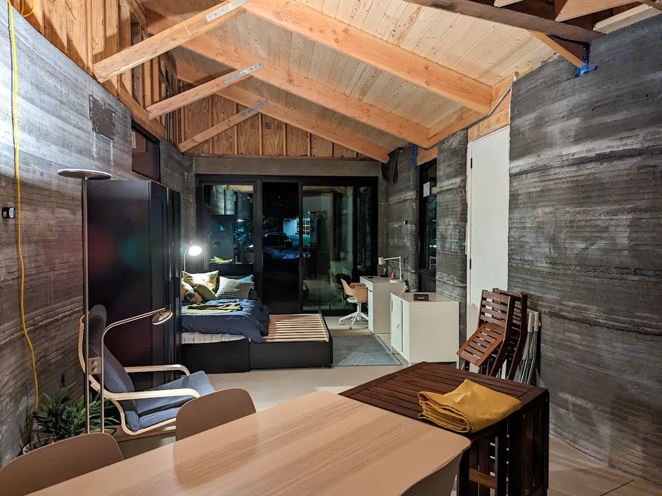 The Solar Futures House features practical spaces like a dining area, kitchen, and a window wall.
