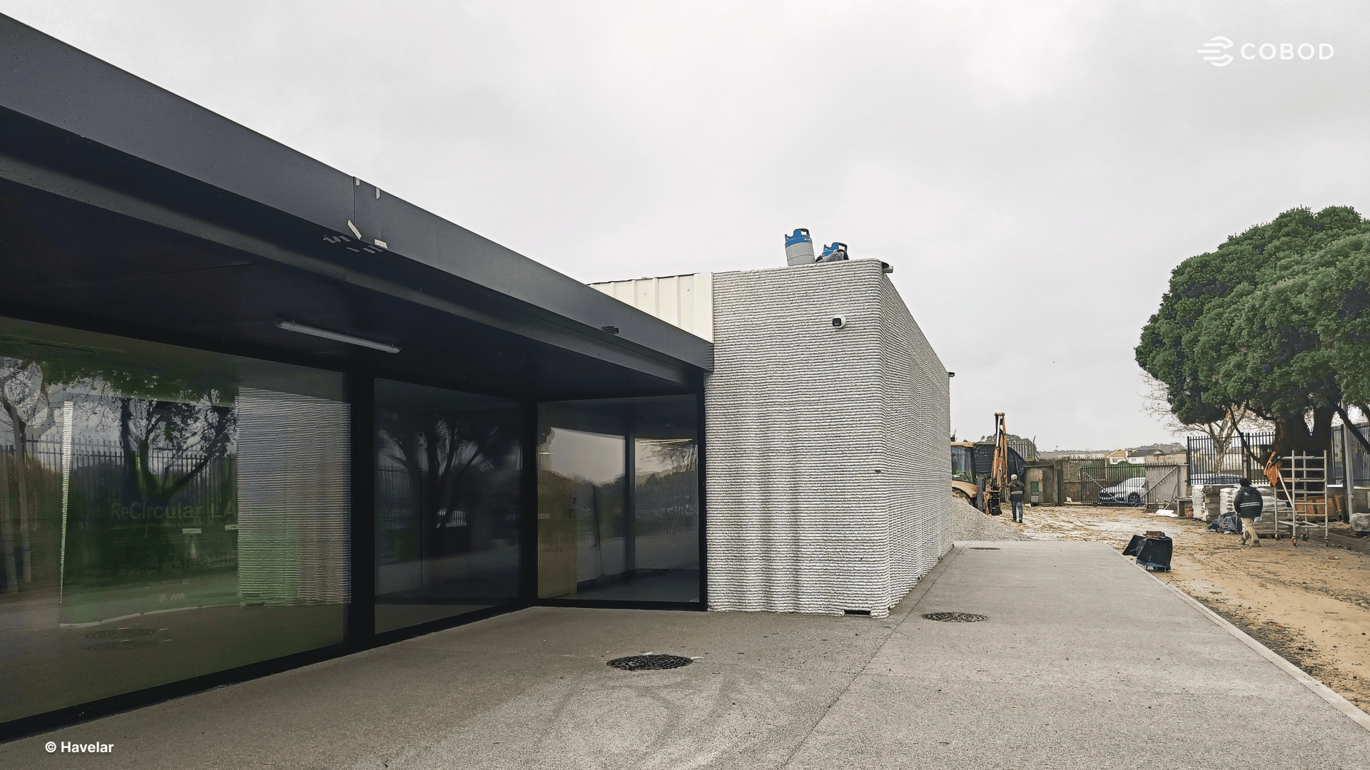 The Ecocentro de Perafita recycling center office under construction, Matosinhos, Portugal. The layered texture of the 3D printed concrete walls is visible on the right.